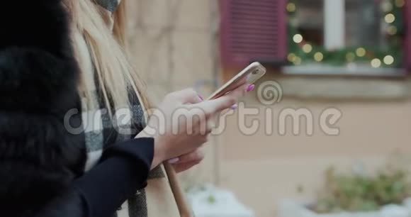 在城市外的寒冷天气里用手机对女性进行猛烈射击技术冬季和假日视频的预览图