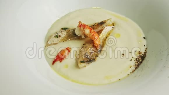 用汤匙把鱼奶油汤配上对虾和香料视频的预览图