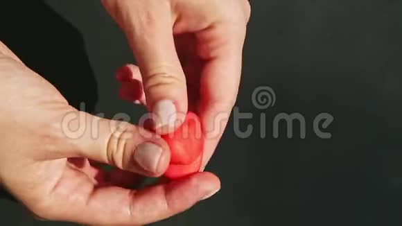 顶部的特写双手由一小块红色的杏仁糖形成心形视频的预览图