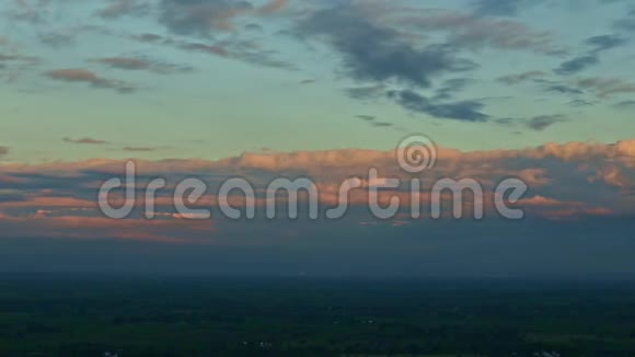 日落时分在蓝天上带着蓬松的粉红色云彩的热带景观留下了缓慢的全景视频的预览图
