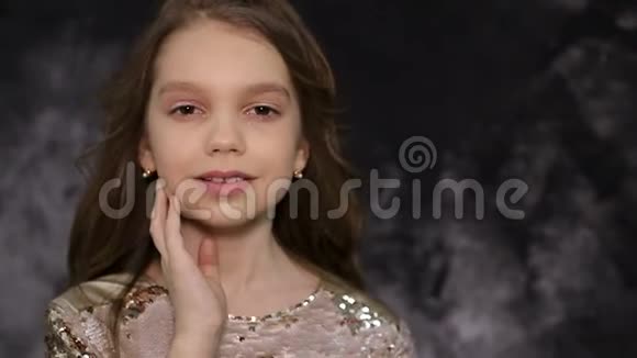 一个美丽的小女孩的肖像灰色背景上有一头漂亮健康的长发视频的预览图