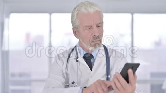老年医生在办公室智能手机上讲话的肖像视频的预览图