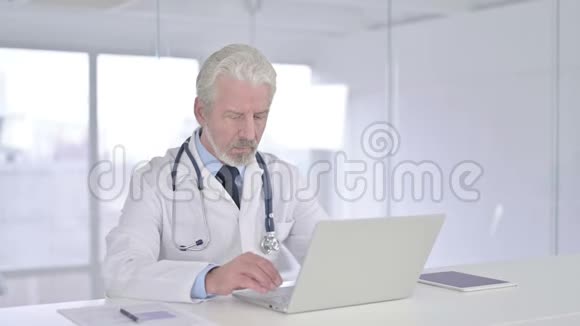 开朗的老医生在笔记本电脑上做视频聊天视频的预览图