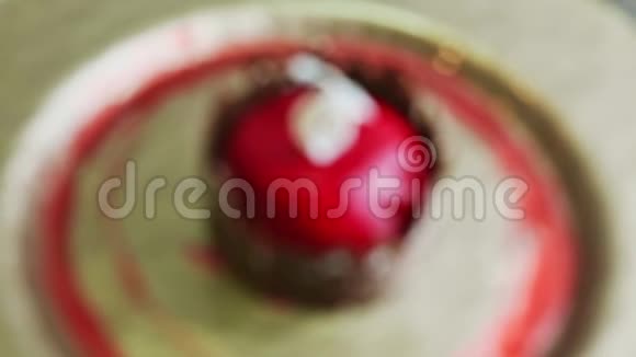 在美味的红色釉面甜点和金色盘子上的巧克力城堡特写视频的预览图