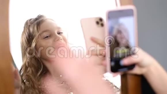小女孩在网上玩的时候拿着手机自拍视频的预览图