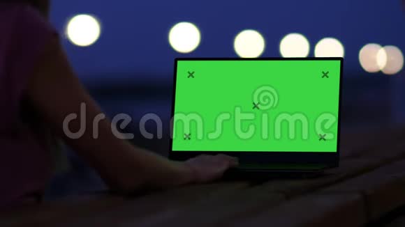 女孩深夜在外面用笔记本电脑视频的预览图