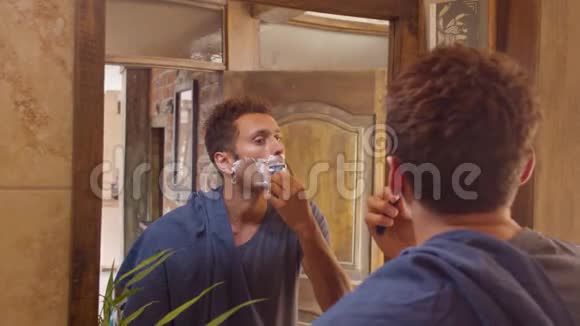 成年男子在浴室镜子里剃胡子视频的预览图