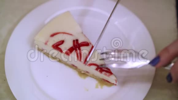 白色盘子上的奶酪蛋糕女人用刀切进去用叉子取一块美味的最爱糕点视频的预览图