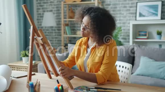 美丽的非裔美国女孩独自在家用铅笔和颜料作画视频的预览图