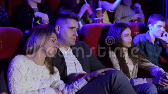 人们在电影院看一部无聊的电影无聊的人在电影院里睡着了视频的预览图