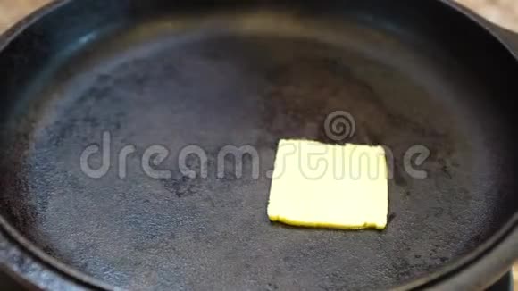 从侧面看铸铁煎锅的黄油熔化视频的预览图