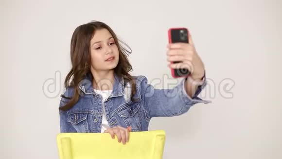 可爱的小女孩在白色背景上拍照宝宝坐在椅子上视频的预览图