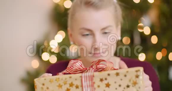 快乐的女人在家里拿着圣诞礼物视频的预览图