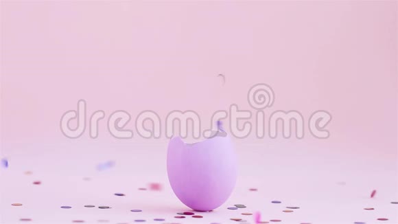 紫色复活节蛋壳上涂上粉红色的背景飞出五颜六色的纸屑鸡蛋是庆祝宗教的象征视频的预览图