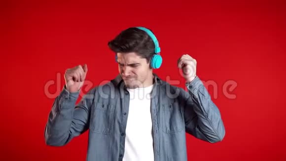 带着耳机的帅哥在红色背景下跳舞派对音乐生活方式收音机和迪斯科的概念视频的预览图