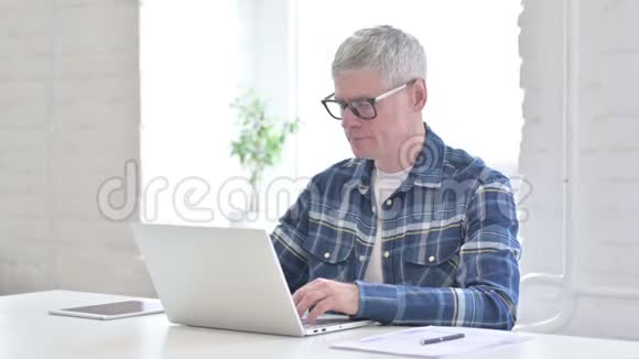专注于笔记本电脑的休闲中年男人视频的预览图