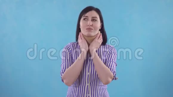 年轻女子戴着护领脖子疼站在蓝底视频的预览图