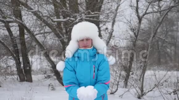 快乐的女孩把雪扔在森林里笑了起来雪落在阳光下闪闪发光一个女人在视频的预览图