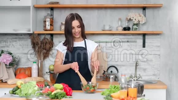 女性手拌新鲜有机蔬菜碗中烹饪素食沙拉特写视频的预览图