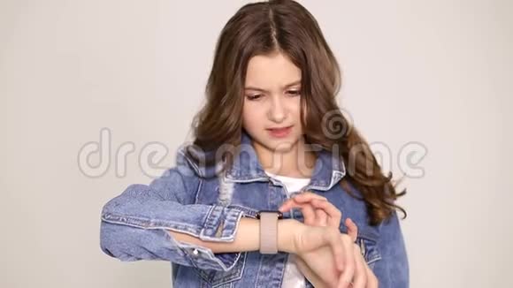 女孩用智能手表做游戏孩子们在社交网络上快乐的青少年视频的预览图