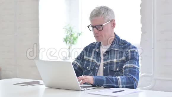生病的休闲中年男子手提电脑和咳嗽视频的预览图