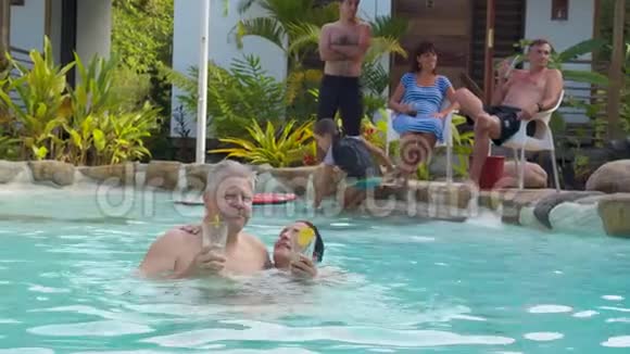 带饮料的不错的成人夫妇享受游泳池视频的预览图