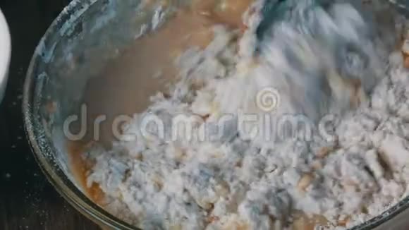 在家庭厨房的透明容器中用特制的木制烤勺揉制家庭面团视频的预览图