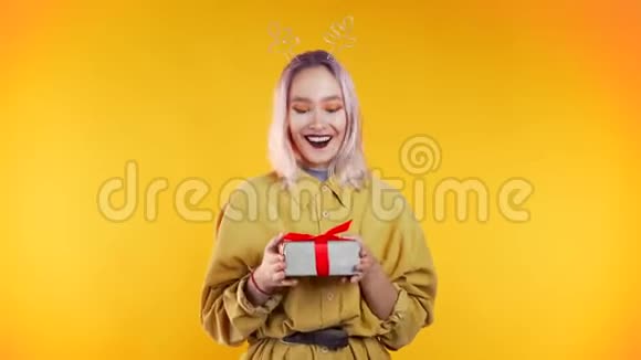 不寻常的女人粉红色的头发微笑后收到礼物在黄色的背景视频的预览图