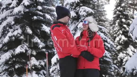 几个滑雪者在白雪皑皑的树林中拥抱视频的预览图