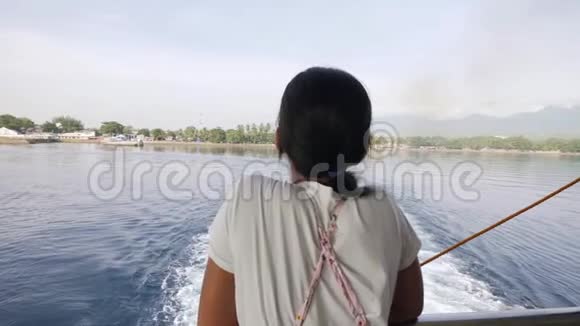 年轻女子站在船甲板上航行时看着大海和风景视频的预览图