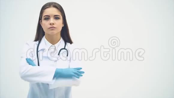 年轻的女医生穿着医疗服凝望镜头表情凝重摆出姿势她视频的预览图