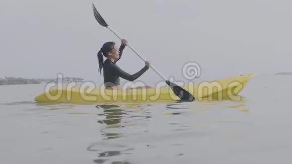 年轻的亚洲女人在卡尔姆海洋划船在暑假视频的预览图