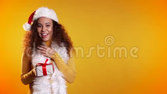 惊讶的混血女人微笑着拿着黄色的礼盒复制空间视频的预览图
