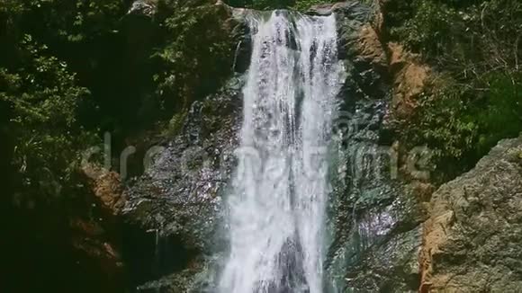 在热带丛林的暗石悬崖上特写强烈的野山瀑布视频的预览图