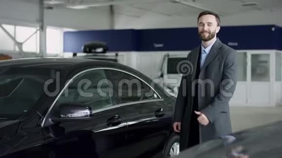 一个男人对汽车展览会上的豪华轿车很感兴趣汽车业务汽车销售技术和人的概念年轻人是视频的预览图
