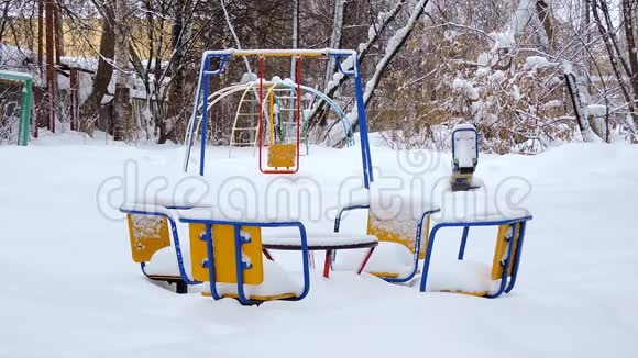 孩子们的秋千在冬天随风摆动孩子们的操场在雪地里视频的预览图