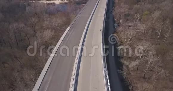 正在建造中的高速公路桥从无人机高度穿过一片森林和一条河流视频的预览图