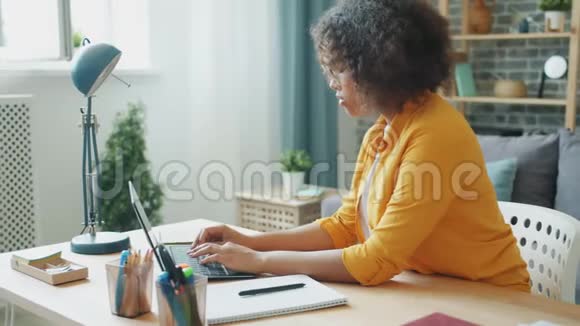 戴眼镜的女学生在家用手提电脑打字视频的预览图