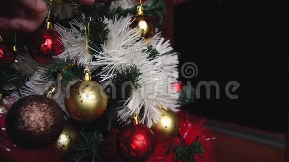 女人旋转金色圣诞球圣诞树装饰细节视频的预览图