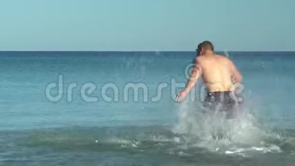 一个年轻人跑到海里摔倒了在地中海游泳的人在海上休息玩得开心视频的预览图
