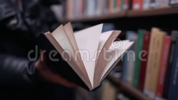 无法辨认的女人在图书馆翻翻了几页旧的纸质书视频的预览图