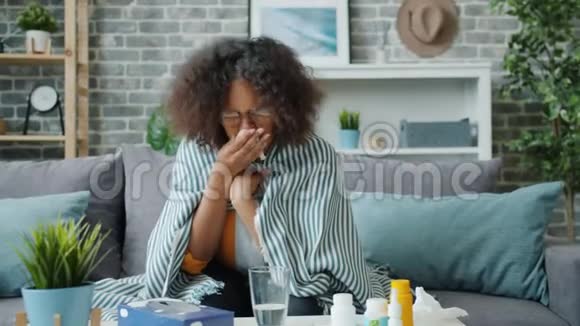 不高兴的非洲裔美国妇女咳嗽在纸组织感觉生病在家视频的预览图