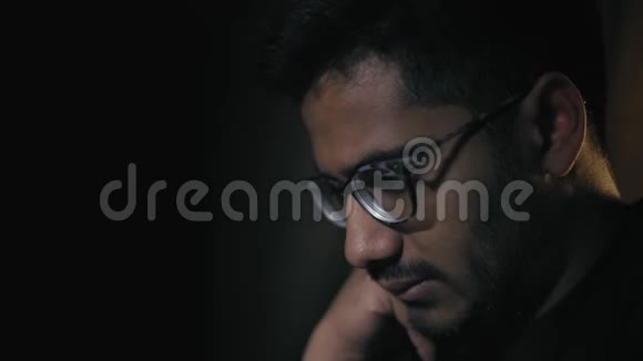 特写镜头戴眼镜的印度男子穿着攻击性的服装看着棋盘游戏中的组合视频的预览图