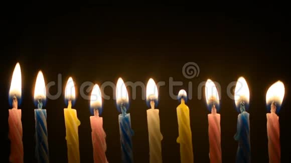 彩色十支蜡烛在黑色背景上燃烧视频的预览图
