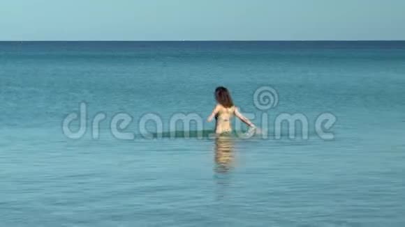 一个年轻的女人在海里四处飞溅穿着地中海泳衣的女人在海上休息玩得开心视频的预览图