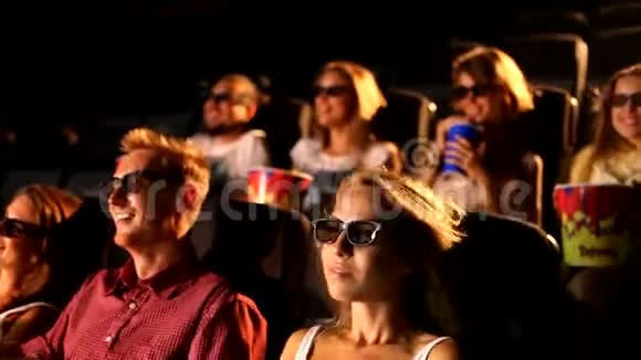 一群兴奋年轻迷人快乐的男性女性朋友在享受3d4d动作电影院吃爆米花视频的预览图
