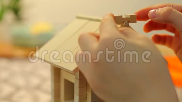 一个男孩正在建造一个玩具屋他把细节放在屋顶上寻求平衡视频的预览图