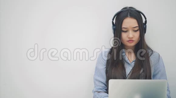 可爱但又疲惫的亚洲女孩长发盘膝手提电脑打哈欠按摩太阳穴有一些视频的预览图