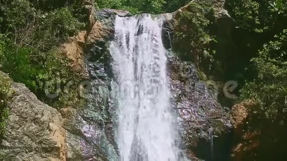 在热带丛林的黑石悬崖上在强烈的山瀑布上慢慢地全景视频的预览图