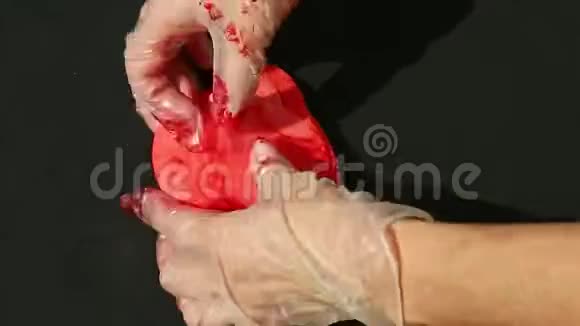 上景特写女人双手捏大块鲜红的杏仁视频的预览图